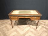 a wooden desk with a glass top on a wooden floor