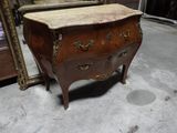 une petite commode dans une pièce où se trouve un miroir