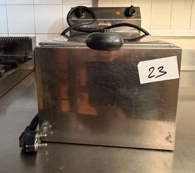 un plan de travail en acier inoxydable sur lequel est posée une friteuse, avec une étiquette de prix dessus