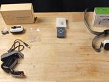 une table en bois avec une boîte, un casque audio, une télécommande et d'autres objets