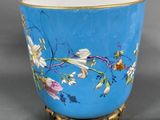 an image of a blue vase with flowers on it on a stand