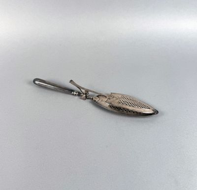 une image représentant une cuillère en argent avec un manche, posée sur une surface blanche