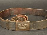 an old belt with a crown buckle on it on a table