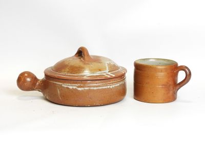 two brown pottery pots and a cup on a white surface