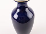 a blue vase with a gold rim on a white background
