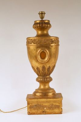 an antique brass urn lamp on a white background