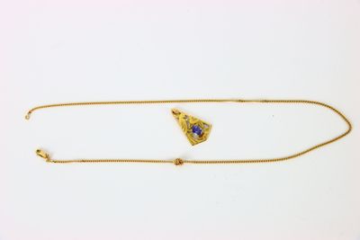 une photo d'un collier en or orné d'une pierre bleue
