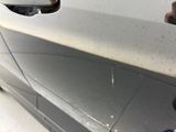 a person holding a cell phone and taking a picture of a car ' s side view mirror