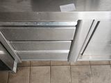 a stainless steel oven in the middle of a tiled floor