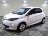 la petite voiture blanche est garée dans la pièce au sol en damier