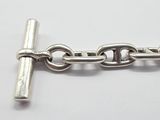 a close up of a silver chain with a cross on it