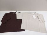 two pairs of t - shirts are sitting on a white surface