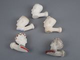 four ceramic figurines of a man and a woman on a gray surface