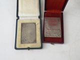 a silver medal in a red box on a white table