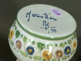 a white vase with a green and yellow design on it