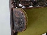 a wooden chair with a green upholstered seat