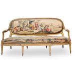 a couch that has a tapestry on it with people on it