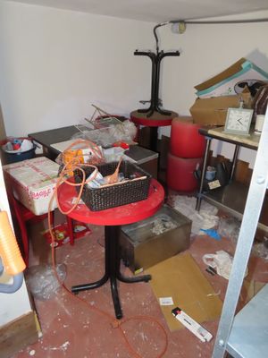 une table rouge sur laquelle se trouve un panier, au milieu d'une pièce