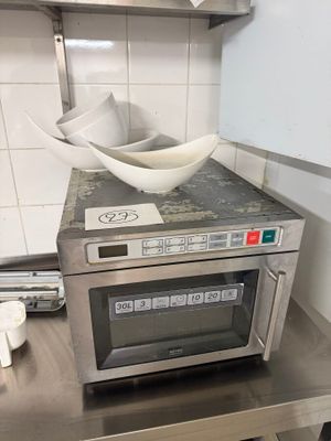 a microwave with a bowl on top of it in a kitchen