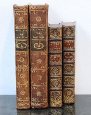 Plusieurs vieux livres sont alignés sur une table noire