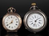 deux horloges posées l'une à côté de l'autre sur une surface noire