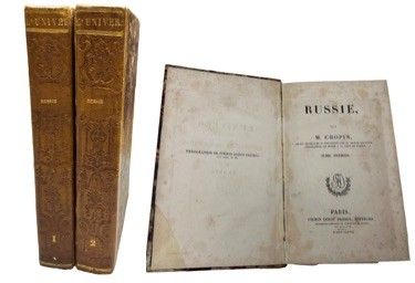 two old books sitting next to each other on a white surface