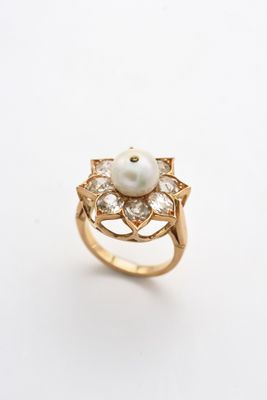 une image d'une bague en perles et diamants sur fond blanc