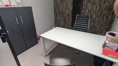un bureau blanc avec une chaise noire et une armoire noire