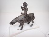 une statue représentant un garçon chevauchant une vache