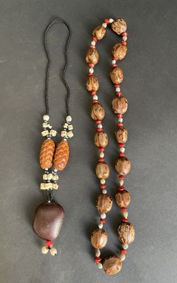 a close up of a necklace and a bead on a table