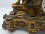 a gold clock with a dog on top of it
