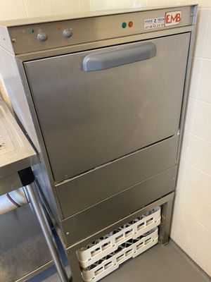 stainless steel dishwasher in a commercial kitchen next to a counter