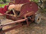 un tracteur rouge garé à côté d'un arbre