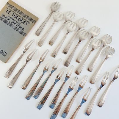 many forks and spoons laid out on the table