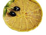 a yellow plate with two black olives on it