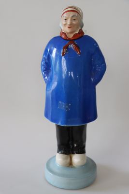 figurine représentant une femme vêtue d'un manteau bleu et d'une écharpe rouge