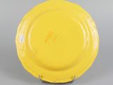 underside view of a yellow plate showing the bottom of the plate