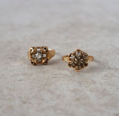 une paire de boucles d'oreilles en or et diamants posées sur un fond blanc