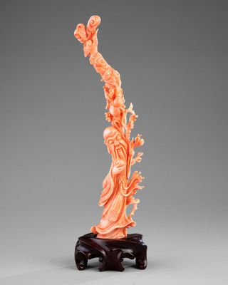 une statue sculptée dans de l'orange représentant une femme, posée sur un socle