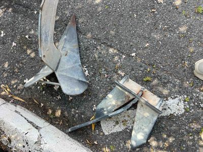 un morceau de métal cassé posé par terre près d'un trottoir