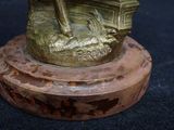 a bronze statue of a boat on a wooden base