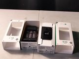 trois téléphones portables qui sont rangés dans des boîtes sur une table