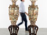 deux grands vases posés sur des socles au milieu d'une pièce