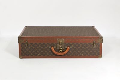 une valise marron posée sur une surface blanche