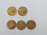 quatre types différents de pièces d'or sur une surface blanche