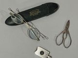 une paire de ciseaux, une paire de lunettes et une autre paire de lunettes posées sur une table