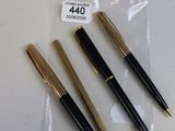 trois stylos qui se trouvent dans un sac posé sur une table