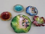 five different colored dishes on a white surface