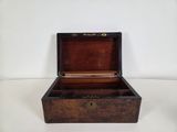 a small wooden box that is open on a white surface