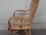a wicker chair that is sitting in front of a white wall